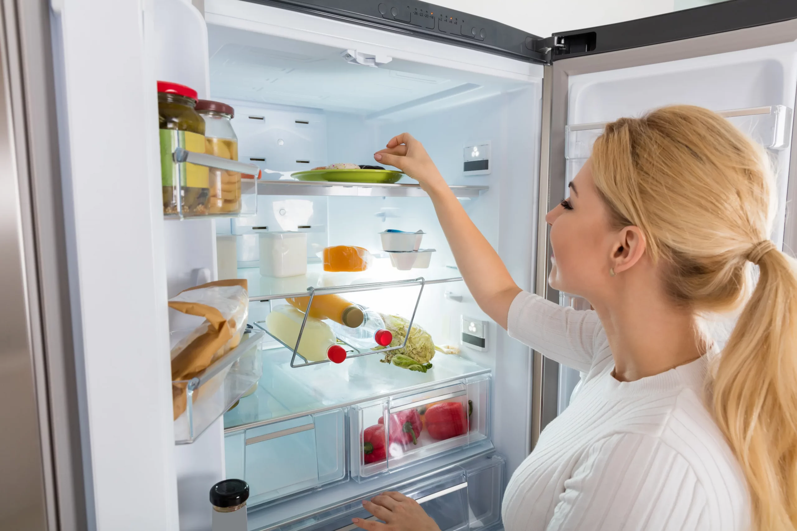 Mujer frigorifico en el hogar